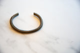 The open, circular form of a collectible antique African bronze cuff.
