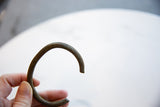 The gentle arc and hand-etched linear details of an antique bronze cuff.