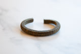 Side view of the collectible African bronze cuff highlighting its striped, textured surface.