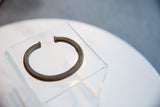 Stylized view of the antique African copper cuff's open shape and etched detailing.