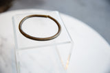 The aged patina and subtly etched line work on a collectible African bronze bracelet.
