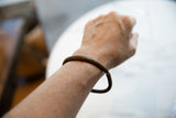 Antique African bronze bracelet worn on the wrist, viewed from above.