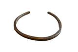 Vintage African bronze artifact with an open cuff shape and hand-etched geometric patterns.