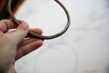 Close-up of the vintage bronze artifact highlighting its handmade geometric detailing.