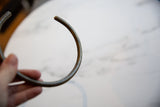 Close-up of the finished tip and aged patina on the African bronze artifact.