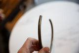 Close view of the solid, rounded edge of the vintage African bronze artifact.