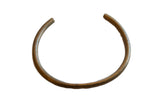 Vintage African bronze artifact with a minimalist C-shape and a naturally aged patina.