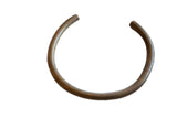 Vintage African bronze artifact with an open cuff shape and a rustic, aged patina.