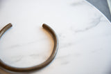 Angled view of the vintage African bronze artifact's open, curved form.