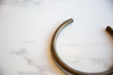 Aged bronze patina on the smooth, rounded end of the vintage African artifact.