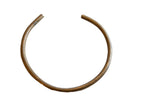 Vintage handmade African bronze artifact with a circular open-cuff design and aged patina.
