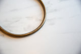 Close-up detail of the vintage bronze artifact's aged patina and smooth curve.