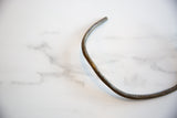 Aged patina and hand-worked texture on the curve of a vintage bronze artifact.
