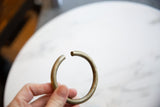 Aged bronze artifact, open circular form with subtle surface variations.