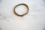 Vintage African bronze artifact with an open-ended shape and weathered surface texture.