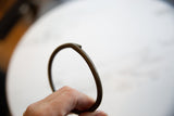 In-hand view showing the scale and aged patina of a vintage bronze artifact.
