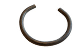 Vintage African bronze artifact with a dark, textured surface and open C-shape.