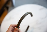 A hand holding the vintage African bronze artifact, showing its scale and textured surface.