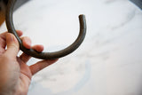 A hand holds the vintage bronze artifact, showing its scale and surface texture.