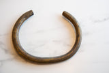 Aged bronze African artifact with a hand-worked texture and a rich, dark patina.