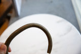 Close-up view of the fine linear texture on the curved bronze artifact.