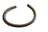 Thick, C-shaped vintage African bronze artifact showing a dark, naturally aged metal patina.