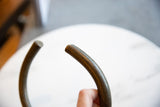 Aged patina and smooth surface on the flat end of the vintage bronze artifact.