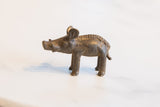 Side profile of a vintage African bronze boar showing its rustic, handmade texture.