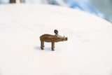 A vintage African bronze boar figurine showing its side profile and rustic texture.