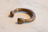 Solid copper alloy terminals of an antique African cuff bracelet showing aged patina.