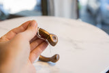 Close-up of the geometric snake head terminal on the antique copper cuff.