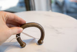 Handheld antique bronze snake cuff bracelet, showing its scale and aged, incised texture.