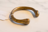 Antique African bronze snake cuff detail, showcasing incised geometric patterns and warm patina.