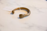Rounded end of the antique African bronze cuff, showing its rich patinated surface and texture.