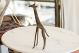 Vintage African bronze giraffe sculpture displaying its slender form and textured patina.