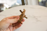 Hand holds vintage African bronze elephant, revealing its unique aged patina.