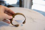Hand-held view of the antique bronze snake cuff showing its scale and ridged texture.
