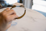 Antique bronze snake cuff bracelet held in hand, showing its scale and aged patina.