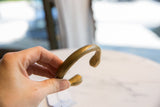 Side view of the antique bronze snake cuff highlighting its curved form and warm patina.
