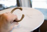 Angled view of the antique bronze cuff, detailing one of the snake heads.