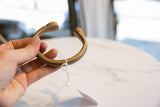 Antique bronze snake cuff bracelet held to display its open shape and authentic patina.