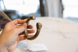 Antique African bronze cuff bracelet held in hand to show its scale and curved form.