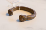 Faceted terminal and engraved scale-like patterns on an antique African snake cuff.