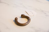 Antique African snake cuff bracelet showing its curved profile and handwritten tag.