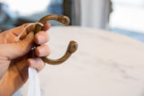 Antique African copper snake cuff bracelet held in hand, showing its scale and form.