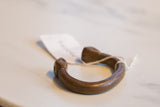 Profile view of the antique African snake cuff's open C-shape and warm patina.
