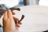 Antique African copper snake cuff held in hand, showing its wearable scale and form.