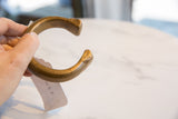 Antique African bronze snake cuff held in hand, showing its substantial form and size.