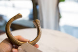Angled profile of an antique African bronze snake cuff with etched terminals.