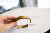 Antique bronze snake cuff bracelet held to show its curved shape and aged patina.